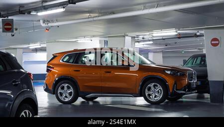 Straßburg, Frankreich - 11. Januar 2025: Ein elektrischer BMW iX1 parkt in der Tiefgarage des Gare de Strasbourg, mit moderner Beleuchtung, direkt Stockfoto