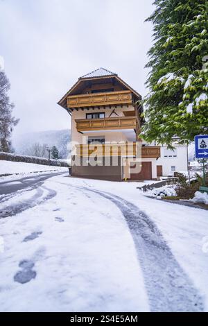 Ein traditionelles, mehrstöckiges Holzhaus im Schnee auf einer Straße, Enzkloesterle, Bezirk Calw, Schwarzwald, Deutschland, Europa Stockfoto