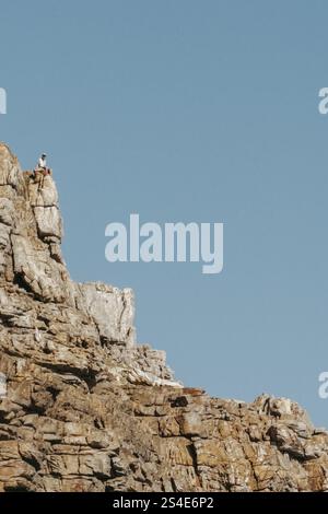 Mann sitzt auf einem Felsen am Kap der Guten Hoffnung Stockfoto