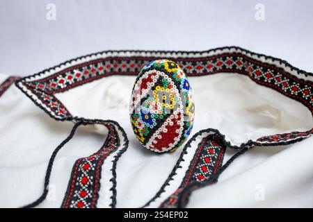 Handgefertigtes osterei mit Perlen. Perlenarbeiten, auf einer rumänischen Bluse oder einem Hemd, weiche Nahaufnahmen Stockfoto
