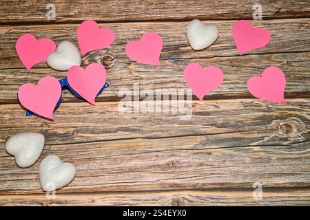 Rosafarbene und weiße Herzen auf gemasertem Holz Stockfoto