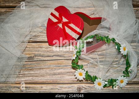 Herzförmige Box und Kranz auf Holz und Tuch Stockfoto