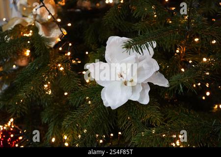Blumenschmuck auf einem Weihnachtsbaum mit Lichtern Stockfoto