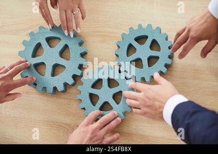 Geschäftsleute verbinden Zahnräder auf dem Tisch, Hände aus nächster Nähe Stockfoto