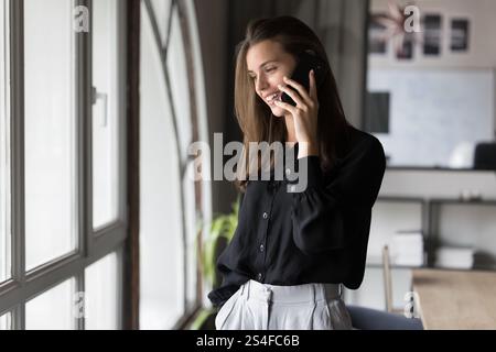 Junge, hübsche Geschäftsfrau, die am Telefon spricht Stockfoto