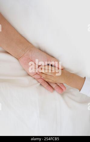 Babyhand in Mutterhand Stockfoto