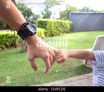 Asiatisches Baby Hände auf Vaterhand Stockfoto