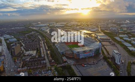 Atemberaubende Luftaufnahmen des Old Trafford Stadium in Manchester, England, umgeben von städtischen und industriellen Landschaften bei Sonnenuntergang. Perfekt für Sport Stockfoto
