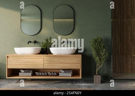 Modernes Bad mit einem schwimmenden Holzwaschtisch, zwei Waschbecken, schwarzen Armaturen und großen Spiegeln. Mit Grün und natürlichem Textil Stockfoto