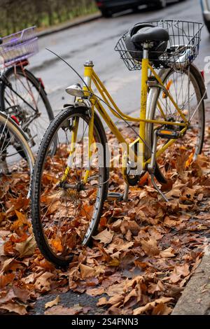 Blick auf ein gelbes kaputtes Fahrrad, das auf einem Parkplatz steht Stockfoto