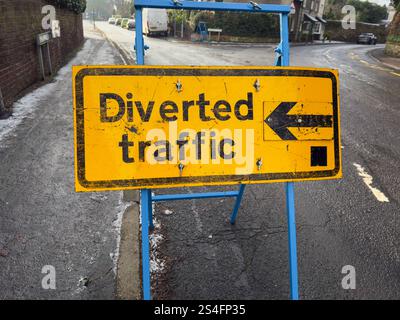 Umgelenkt Verkehrsschild mit Pfeil nach links. Gelbes Straßenschild in Großbritannien in Nahaufnahme, das eine Umleitung oder Umleitung anzeigt. Stockfoto