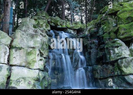 Der wunderschöne Wasserfall fällt über moosbedeckte Felsen in einer ruhigen Waldlandschaft Stockfoto