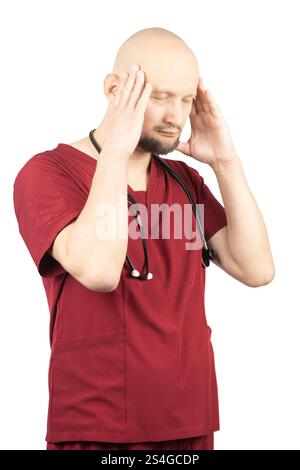 Ein glatzköpfiger Arzt mit Bart, in roten Peelings gekleidet und ein Stethoskop um den Hals trägt, hält seinen Kopf mit beiden Händen und schließt ihn Stockfoto