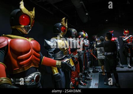 Ein Fan der Kamen-Rider-Serie macht ein Foto mit der Nachbildung des Kamen-Riders während der Ausstellung zum 50. Jahrestag des Kamen-Riders in Kuala Lumpur, Malaysia, am 12. Januar 2025. Die Ausstellung feiert die legendäre japanische Superheldenreihe, die Fans seit Generationen in ihren Bann zieht. Über 50 lebensgroße Nachbildungen von Kamen Riders und Requisiten aus den Showa-, Heisei- und Reiwa-Zeiten erwecken die Kamen Rider-Charaktere durch Originalkostüme, ikonische Requisiten und reproduzierte Manga-Panels zum Leben. (Foto: Hari Anggara/NurPhoto) Stockfoto