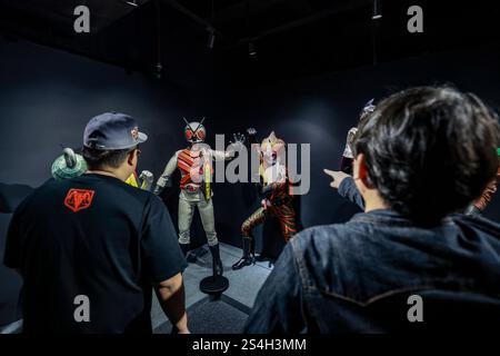 Ein Fan der Kamen-Rider-Serie macht ein Foto mit der Nachbildung des Kamen-Riders während der Ausstellung zum 50. Jahrestag des Kamen-Riders in Kuala Lumpur, Malaysia, am 12. Januar 2025. Die Ausstellung feiert die legendäre japanische Superheldenreihe, die Fans seit Generationen in ihren Bann zieht. Über 50 lebensgroße Nachbildungen von Kamen Riders und Requisiten aus den Showa-, Heisei- und Reiwa-Zeiten erwecken die Kamen Rider-Charaktere durch Originalkostüme, ikonische Requisiten und reproduzierte Manga-Panels zum Leben. (Foto: Hari Anggara/NurPhoto) Stockfoto