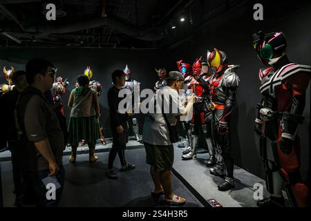 Ein Fan der Kamen-Rider-Serie macht ein Foto mit der Nachbildung des Kamen-Riders während der Ausstellung zum 50. Jahrestag des Kamen-Riders in Kuala Lumpur, Malaysia, am 12. Januar 2025. Die Ausstellung feiert die legendäre japanische Superheldenreihe, die Fans seit Generationen in ihren Bann zieht. Über 50 lebensgroße Nachbildungen von Kamen Riders und Requisiten aus den Showa-, Heisei- und Reiwa-Zeiten erwecken die Kamen Rider-Charaktere durch Originalkostüme, ikonische Requisiten und reproduzierte Manga-Panels zum Leben. (Foto: Hari Anggara/NurPhoto) Stockfoto