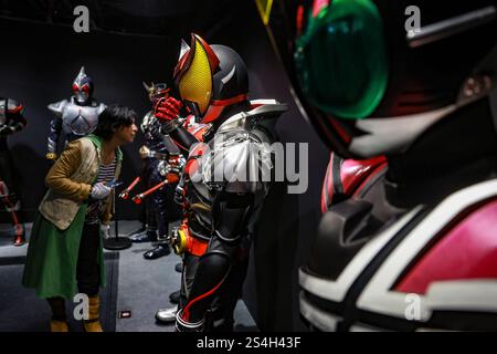 Ein Fan der Kamen-Rider-Serie macht ein Foto mit der Nachbildung des Kamen-Riders während der Ausstellung zum 50. Jahrestag des Kamen-Riders in Kuala Lumpur, Malaysia, am 12. Januar 2025. Die Ausstellung feiert die legendäre japanische Superheldenreihe, die Fans seit Generationen in ihren Bann zieht. Über 50 lebensgroße Nachbildungen von Kamen Riders und Requisiten aus den Showa-, Heisei- und Reiwa-Zeiten erwecken die Kamen Rider-Charaktere durch Originalkostüme, ikonische Requisiten und reproduzierte Manga-Panels zum Leben. (Foto: Hari Anggara/NurPhoto) Stockfoto