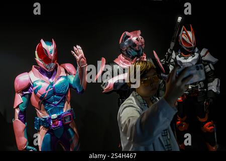 Ein Fan der Kamen-Rider-Serie macht ein Selfie mit der Nachbildung des Kamen-Riders während der 50. Jubiläumsausstellung in Kuala Lumpur, Malaysia, am 12. Januar 2025. Die Ausstellung feiert die legendäre japanische Superheldenreihe, die Fans seit Generationen in ihren Bann zieht. Über 50 lebensgroße Nachbildungen von Kamen Riders und Requisiten aus den Showa-, Heisei- und Reiwa-Zeiten erwecken die Kamen Rider-Charaktere durch Originalkostüme, ikonische Requisiten und reproduzierte Manga-Panels zum Leben. (Foto: Hari Anggara/NurPhoto) Stockfoto