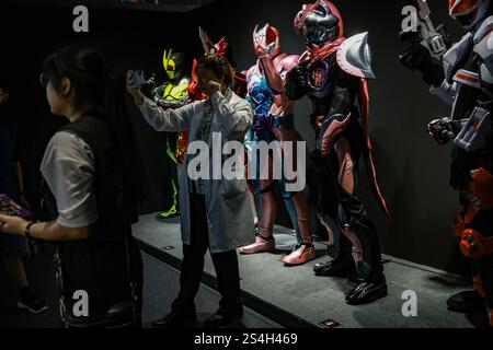 Ein Fan der Kamen-Rider-Serie macht ein Selfie mit der Nachbildung des Kamen-Riders während der 50. Jubiläumsausstellung in Kuala Lumpur, Malaysia, am 12. Januar 2025. Die Ausstellung feiert die legendäre japanische Superheldenreihe, die Fans seit Generationen in ihren Bann zieht. Über 50 lebensgroße Nachbildungen von Kamen Riders und Requisiten aus den Showa-, Heisei- und Reiwa-Zeiten erwecken die Kamen Rider-Charaktere durch Originalkostüme, ikonische Requisiten und reproduzierte Manga-Panels zum Leben. (Foto: Hari Anggara/NurPhoto) Stockfoto