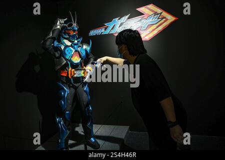 Ein Fan der Kamen-Rider-Serie macht ein Foto mit der Nachbildung des Kamen-Riders während der Ausstellung zum 50. Jahrestag des Kamen-Riders in Kuala Lumpur, Malaysia, am 12. Januar 2025. Die Ausstellung feiert die legendäre japanische Superheldenreihe, die Fans seit Generationen in ihren Bann zieht. Über 50 lebensgroße Nachbildungen von Kamen Riders und Requisiten aus den Showa-, Heisei- und Reiwa-Zeiten erwecken die Kamen Rider-Charaktere durch Originalkostüme, ikonische Requisiten und reproduzierte Manga-Panels zum Leben. (Foto: Hari Anggara/NurPhoto) Stockfoto