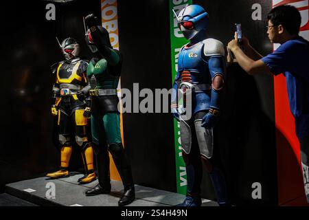 Ein Fan der Kamen-Rider-Serie macht ein Foto mit der Nachbildung des Kamen-Riders während der Ausstellung zum 50. Jahrestag des Kamen-Riders in Kuala Lumpur, Malaysia, am 12. Januar 2025. Die Ausstellung feiert die legendäre japanische Superheldenreihe, die Fans seit Generationen in ihren Bann zieht. Über 50 lebensgroße Nachbildungen von Kamen Riders und Requisiten aus den Showa-, Heisei- und Reiwa-Zeiten erwecken die Kamen Rider-Charaktere durch Originalkostüme, ikonische Requisiten und reproduzierte Manga-Panels zum Leben. (Foto: Hari Anggara/NurPhoto) Stockfoto