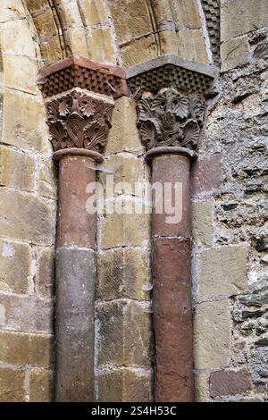 Kunstvolle Steinsäulen mit detaillierten Schnitzereien unterstreichen die reiche Geschichte und Kunstfertigkeit in Conques, Frankreich. Stockfoto