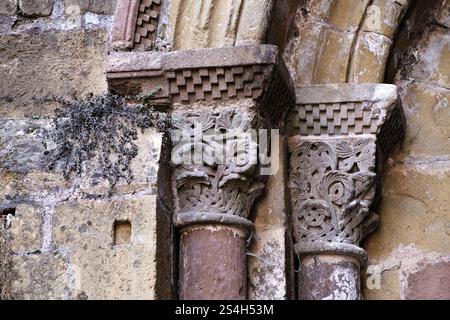 Kunstvolle Steinsäulen mit detaillierten Schnitzereien unterstreichen die reiche Geschichte und Kunstfertigkeit in Conques, Frankreich. Stockfoto