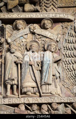 Die aufwendigen Skulpturen zeigen biblische Figuren und Motive entlang des Eingangs der Kirche in Conques. Stockfoto