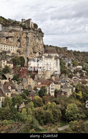 Rocamadour bietet atemberaubende Architektur an den Klippen inmitten von üppigem Grün und dramatischem Himmel, reich an Geschichte. Stockfoto
