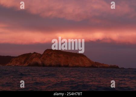 Huatulco, Mexiko. Januar 2025. Die Berge werden durch den Sonnenuntergang in der Nähe der Bucht von Cacaluta, Teil des Huatulco National Reserve, in Santa Maria Huatulco gesehen. Der Huatulco-Nationalpark ist ein staatlich geschütztes Naturgebiet mit vorrangigen Ökosystemen, die für die mexikanische Artenvielfalt repräsentativ sind. Am 11. Januar 2025 in Huatulco, Mexiko. (Foto: Carlos Santiago/Eyepix Group/SIPA USA) Credit: SIPA USA/Alamy Live News Stockfoto
