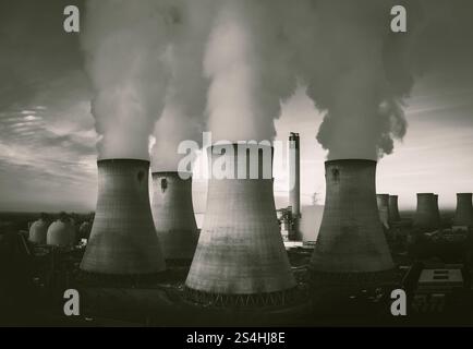 Eine vertikale Luftaufnahme einer Gruppe von Kühltürmen in einem Kohlekraftwerk mit Kohlendioxidemissionen in einem schmutzigen oder verschmutzten Luftkonzept in Stockfoto