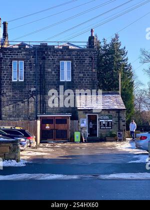 Burley in Wharfedale England Großbritannien Britisches England Yorkshire Großbritannien Schnee Eis Weihnachtsdorf Zentrum Geschäfte Straßenlaternen Straßenweg Pflaster alter Stein Stockfoto
