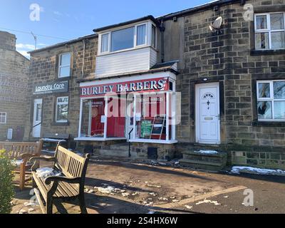 Burley in Wharfedale England Großbritannien Britisches England Yorkshire Großbritannien Schnee Eis Weihnachtsdorf Zentrum Geschäfte Straßenlaternen Straßenweg Pflaster alter Stein Stockfoto