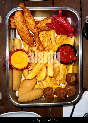Verschiedene Biersnacks, Chicken Nuggets, Pommes frites, Shrimps Temputa und Chicken Wings in der Pub Bar Stockfoto
