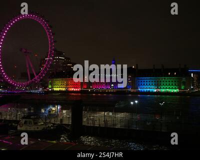 Das House of Parliament und das London Eye leuchteten nachts in Regenbogenfarben, um den Stolz-Monat im Februar in London zu feiern Stockfoto