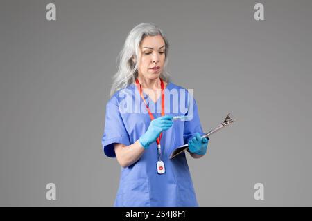 Frau mittleren Alters in Peelings mit Klemmbrett und Stift Stockfoto