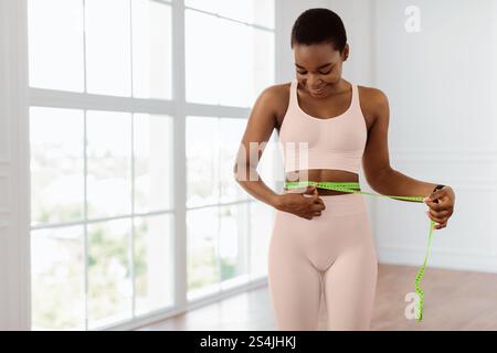 Happy Sporty Woman Misst Taille Mit Klebeband. Diät-Schlankheitskonzept Stockfoto