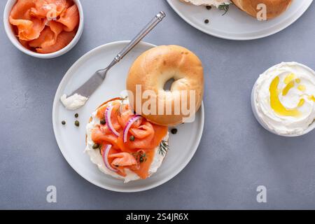 Überzogener Räucherlachs-Bagel mit Frischkäse auf einem modernen Küchentisch Stockfoto