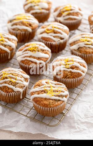 Frisch gebackene Zitronenzucchini-Muffins mit Zuckerguss und Schale auf einem Kühlregal Stockfoto