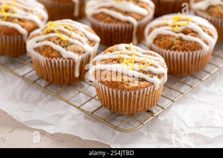 Frisch gebackene Zitronenzucchini-Muffins mit Zuckerguss und Schale auf einem Kühlregal Stockfoto