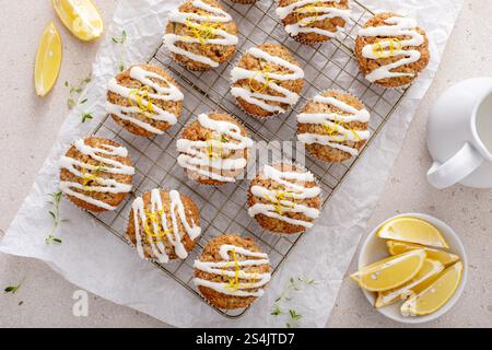 Frisch gebackene Zitronenzucchini-Muffins mit Zuckerguss und Schale auf einem Kühlregal Stockfoto