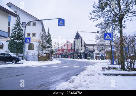 Schneebedeckte Straße in einem Dorf umgeben von traditionellen Häusern und Straßenschildern, Enzkloesterle, Bezirk Calw, Schwarzwald, Deutschland, Europa Stockfoto
