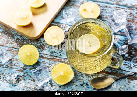 Frisches, geeistes Zitronentee-Limonade im Glas auf einem Holztisch aus Grunge. Im Glas befinden sich frische Zitronenscheiben. Alkoholfreies Getränk für heißes Wetter. Stockfoto