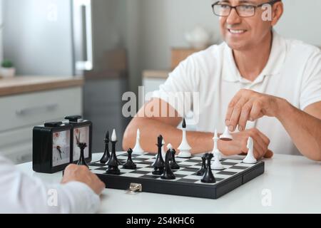 Seniorenpaar, das zu Hause gemeinsam Schach spielt Stockfoto