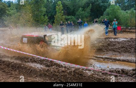 Moment eines schnellen Geländefahrzeugs, das durch eine schwierige Schlammstrecke navigiert und die Spannung und Intensität des Motorsports zeigt. Stockfoto