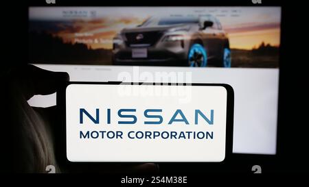 Deutschland. Oktober 2024. In dieser Abbildung hält eine Person ein Handy mit dem Logo der japanischen Firma Nissan Motor Corporation auf dem Bildschirm vor der Webseite. Quelle: SOPA Images Limited/Alamy Live News Stockfoto