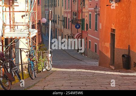 Haus und Straße in Ligurien. Baugerüste und Färbung der Gebäudefassade. Stadtgebäude an sonnigen Tagen. Reisen, Sightseeing und Stockfoto