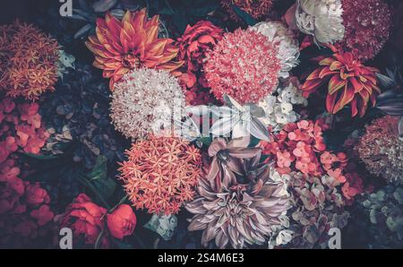 Eine Nahaufnahme im Vintage-Stil mit einem lebendigen Arrangement künstlicher Blumen, die an ein chinesisches Neujahrsfest erinnern. Das Bild zeigt einen Stockfoto