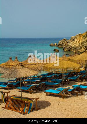 Ein Resort am Prinos Beach am südlichen Ende der Himare Bay an der Küste Südalbaniens, Teil der albanischen Riviera. Ein Morgen im Juni, Frühsommer Stockfoto