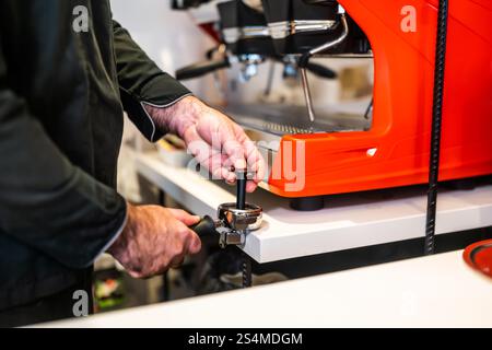 Nahaufnahme eines professionellen Barista mit einer Espressomaschine. Stockfoto